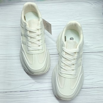 Бежевые кроссовки на высокой подошве.